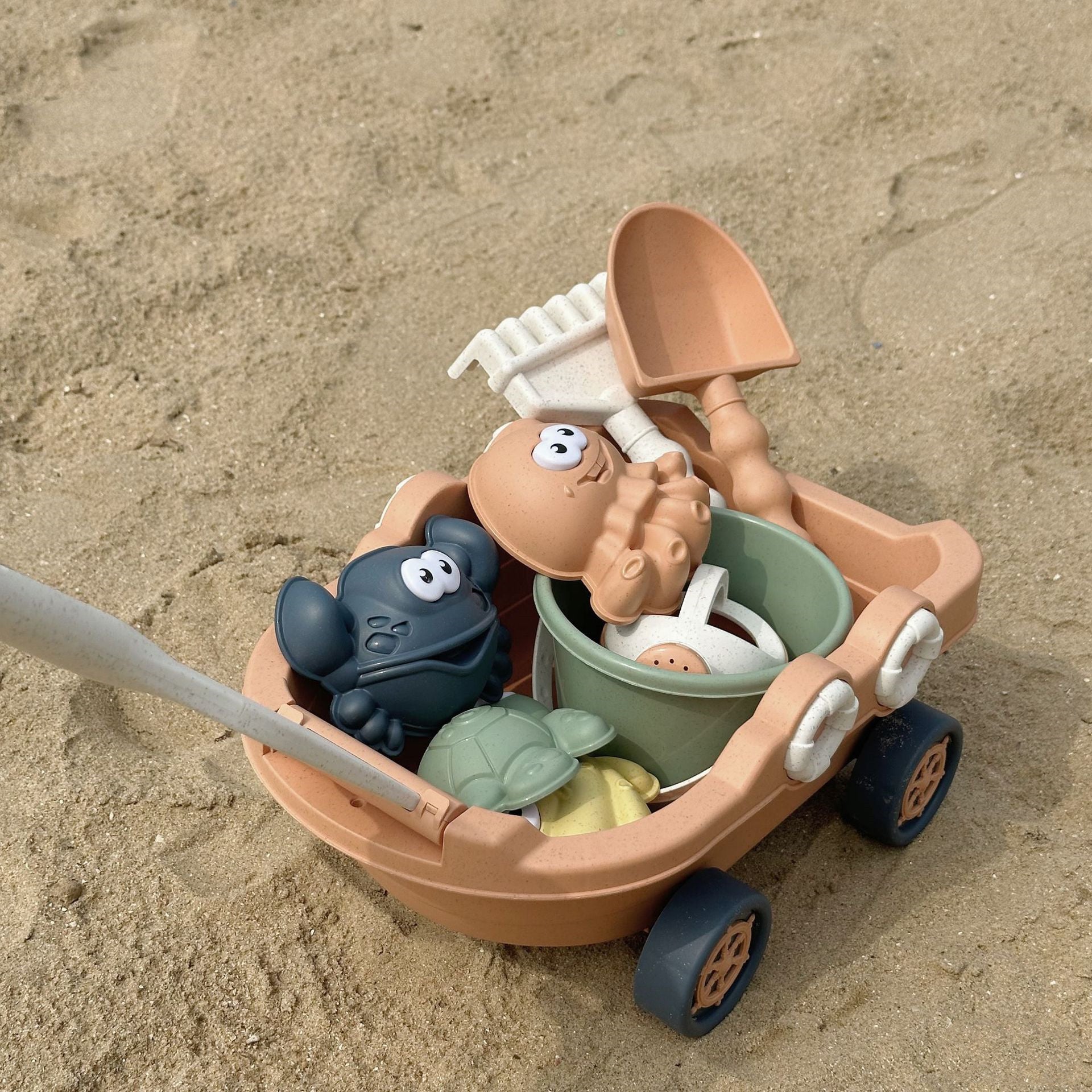 Toy sand vehicle with figures on a sandy surface